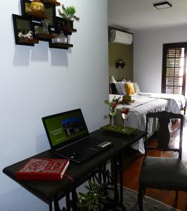 ein Laptop, der auf einem Tisch in einem Zimmer steht in der Unterkunft Hospedaria Canto do Vinhedo in Espirito Santo Do Pinhal