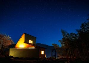 a small house lit up at night at OKANiWA 丘庭 in Nagiso