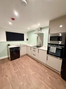 a kitchen with a stove and a dishwasher at Aire House, Keighley in Keighley