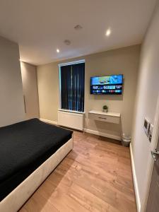 a bedroom with a bed and a flat screen tv at Aire House, Keighley in Keighley