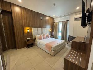 a hotel room with a bed and a television at Hôtel La Pivoine in Abidjan