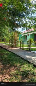 a house with a fence next to a walkway at Pross Residence in Masindi