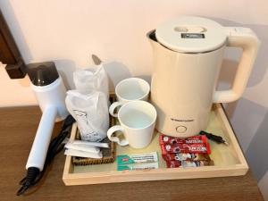 a coffee maker and cups on a wooden tray at Hi2 Cha-Am in Cha Am