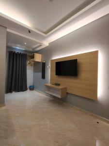 a living room with a flat screen tv on a wall at Rimba Inn in Kijal