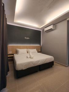 a bedroom with a bed with white sheets at Rimba Inn in Kijal