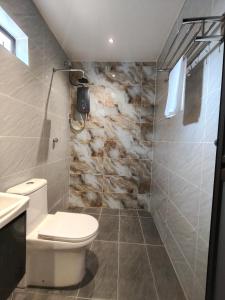 a bathroom with a white toilet and a sink at Rimba Inn in Kijal +24 photos