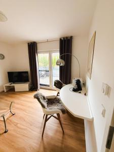 a room with a table and a chair and a lamp at Ferienwohnung RuheOase in Steinheim