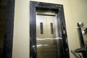 a mirror in a bathroom with a silver elevator at hotel nemi residency jagdalpur in Jagdalpur