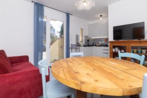 a dining room with a wooden table and a red chair at Casa Brezza Marina in Punta Marina