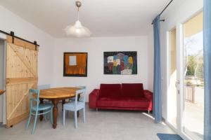 a dining room with a red couch and a table at Casa Brezza Marina in Punta Marina