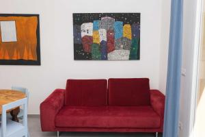 a red couch in a living room with a painting at Casa Brezza Marina in Punta Marina