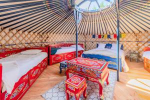 a room with a yurt with two beds and a table at Yourte mongole insolite en pleine nature in Pouilly-sous-Charlieu