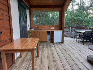 a screened in porch with a table and a sink at CHALET A NATURISTE Le TIKI in Le Porge