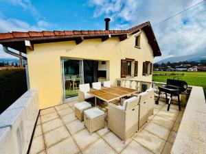 a patio with a table and chairs and a house at Nouveauté Gite la virée verte in Vagney