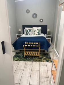 a bedroom with a bed with a blue blanket at Happy Daze Spacious 45m2 Self Catering Apartment in Swellendam