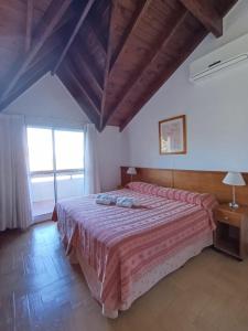 a bedroom with a large bed with a red bedspread at Rincon del Valle in Merlo +23 photos