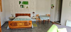 a bedroom with a bed and a table with a chair at Les Chambres du Relais in Liettres