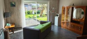 a living room with a couch and a mirror at Les Chambres du Relais in Liettres
