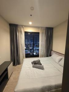 a bedroom with a large white bed with a window at The Base Central Pattaya in Pattaya +18 photos