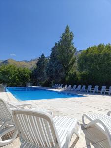 a swimming pool with white chairs and a bunch ofitures at Rincon del Valle in Merlo