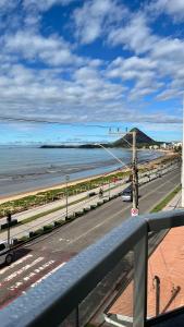 a view of a highway with a beach and the ocean at Hotel Polonini in Piúma