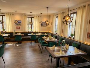 a dining room with tables and green chairs at Hotel & Restaurant Krone in Märkt in Weil am Rhein
