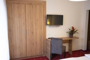 a room with a desk and a television on a wall at Hotel Drescher in Mörbisch am See