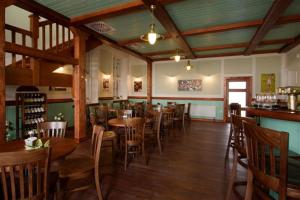 ein Restaurant mit Holztischen und -stühlen und einer Bar in der Unterkunft Hotel Dakol in Petrovice u Karviné