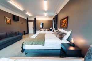a hotel room with three beds and a couch at Ljosafoss Lake Guest House in Selfoss