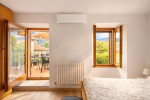 a bedroom with a bed and a view of a patio at Apartment Cà Dai Noni - Family & Pet Friendly - Terrace - Near Lake Maggiore in Feriolo