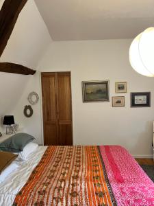 a bedroom with a large bed with a red blanket at La Gruchette in Gruchet-Saint-Siméon