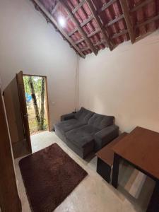 a living room with a couch and a table at Casa na Mata - 2 min da Praia de fora com WiFi in Paraty