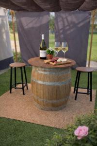 a table with two glasses of wine and two stools at Roulotte insolite in Veaugues +5 photos
