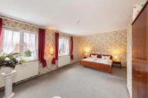 a bedroom with a bed in a room with floral wallpaper at Hotel & Restaurant Krone in Märkt in Weil am Rhein