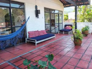 a patio with a hammock on a house at Hostel Terra das Tribos in Ubatuba