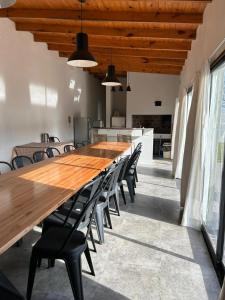 a long wooden table and chairs in a room at Quinta Las Lilas in Chivilcoy