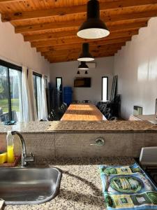 a kitchen with a counter with a sink and a table at Quinta Las Lilas in Chivilcoy
