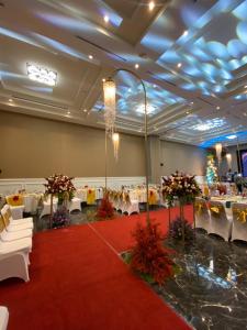 a banquet hall with white tables and a red carpet at Griya Pastoral in Denpasar +43 photos