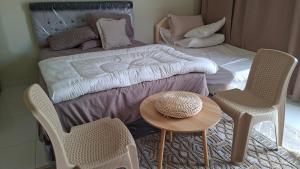 a room with a bed and two chairs and a table at شاليهات رمال بديه in Al Raka +44 photos