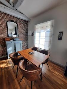 a dining room with a wooden table and chairs at La Grange de Lilou in Aiffres