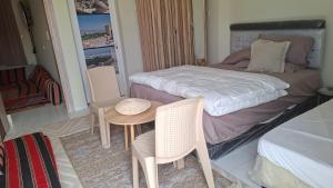 a small room with a bed and a table and chairs at شاليهات رمال بديه in Al Raka