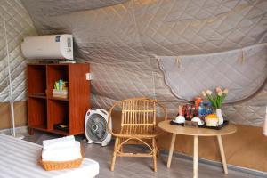 a room with a table and a chair in a yurt at Trám House in Cao Phong