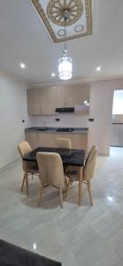 a dining room with a black table and chairs at Appartement 2 chambres in Selouane