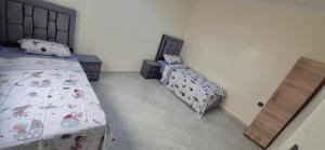 a bedroom with two twin beds and a bed with a comforter at Appartement 2 chambres in Selouane