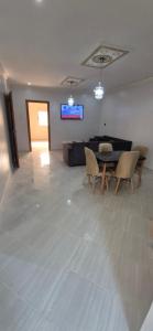 a living room with a table and chairs and a couch at Appartement 2 chambres in Selouane