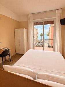 a large bed in a room with a large window at Hotel Elisabetta in Sestri Levante