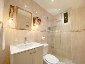 a bathroom with a toilet and a sink and a shower at Colonial Zone 2BR Apartment Prime Location in Santo Domingo +8 photos