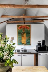 a kitchen with a bottle of whisky on the wall at Bed and Breakfast Lovenem - ruime studio met zwembad en sauna op de Veluwe in Leuvenheim +2 photos