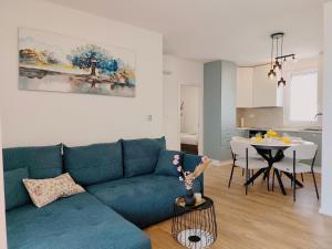 a living room with a blue couch and a table at Nashi Garden Apartment Split with City View & Parking in Solin