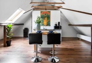 an attic kitchen with a table and two chairs at Bed and Breakfast Lovenem - ruime studio met zwembad en sauna op de Veluwe in Leuvenheim
